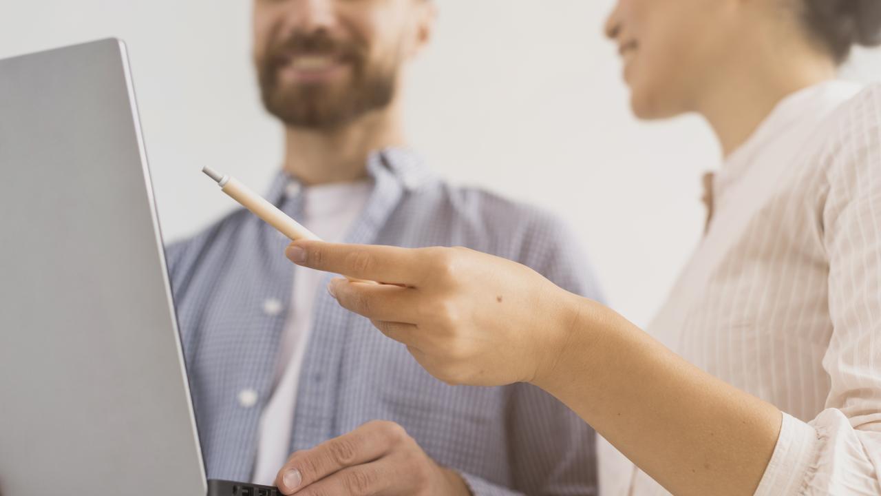 Home i dona davant de l'ordinador compartint informació